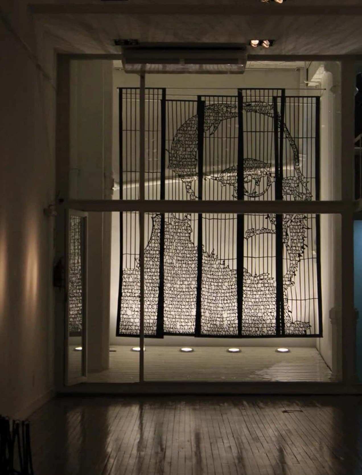 Retrato: un rostro hecho de texto calado, en una vidriera del Museo Figari