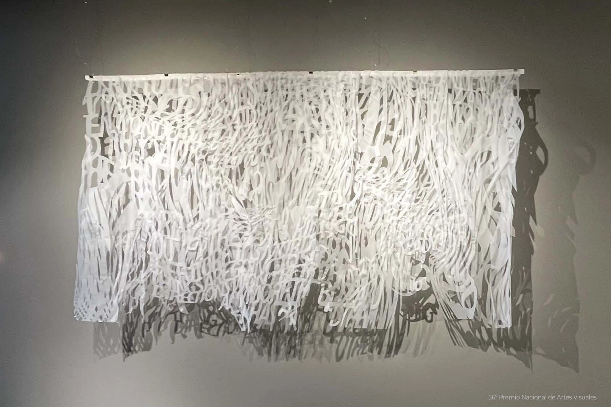 The Future: papel vegetal blanco calado, con letras que se deshacen hacia abajo y su sombra en la pared